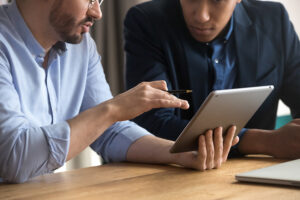 two workers having a meeting using a tablet connect to to the business cloud